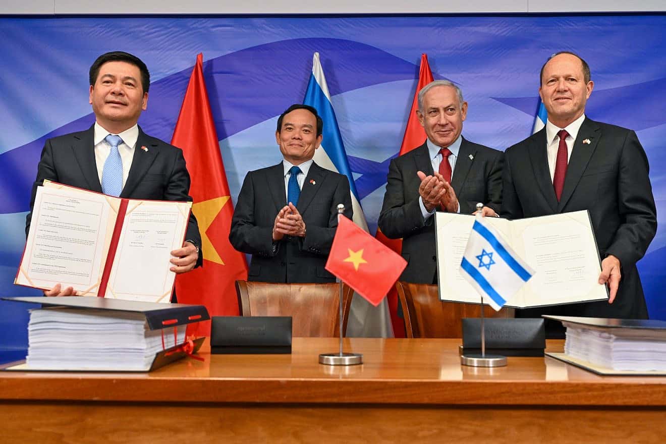 Vietnamese Minister of Industry and Trade Nguyen Hong Dien and Israeli Economy Minister Nir Barkat hold copies of a signed free trade agreement at the Prime Minister's Office in Jerusalem as Prime Minister Benjamin Netanyahu and Vietnamese Deputy Prime Minister Tran Luu Quang applaud, July 25, 2023. Photo by Kobi Gideon/GPO.